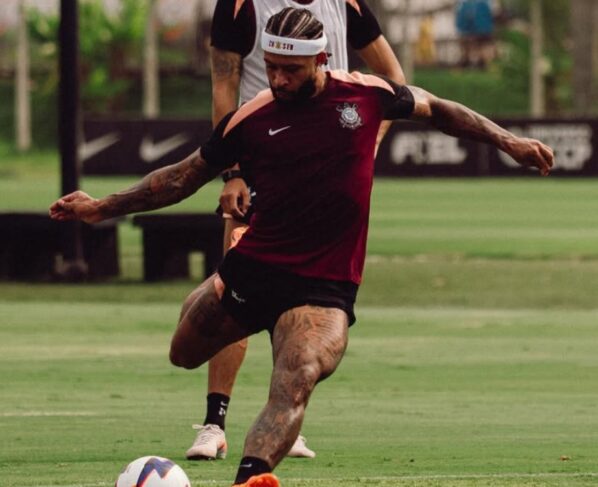 Jogador Memphis Depay é advertido por uso de celular durante partida de futebol.