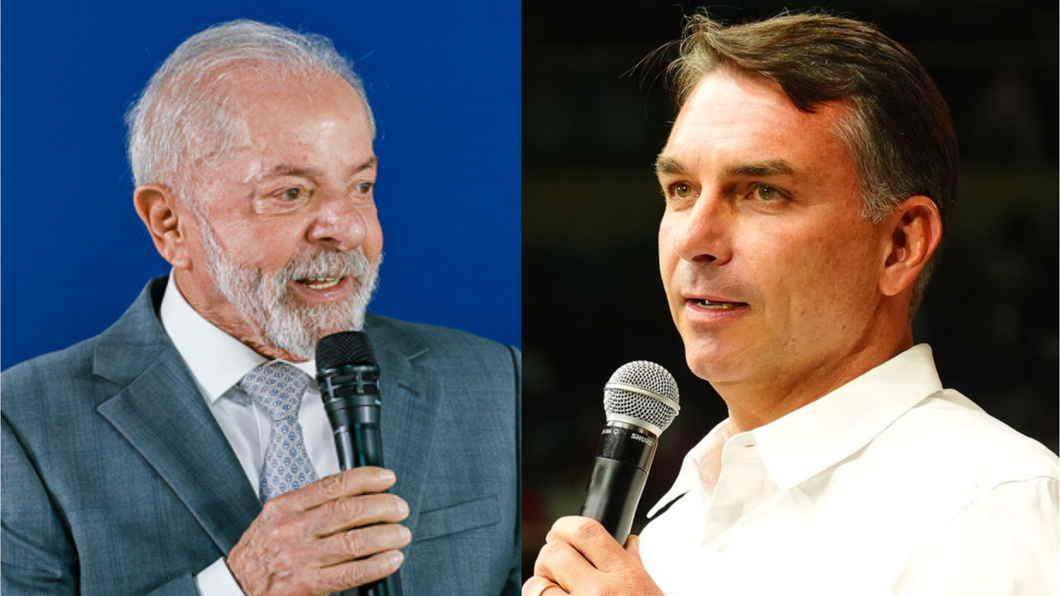 Fotografia jornalística dividida ao meio composta por dois retratos em plano médio curto de figuras políticas brasileiras discursando com microfone em mãos; à esquerda, o presidente Luiz Inácio Lula da Silva, homem idoso de cabelos e barba brancos, veste terno cinza, camisa branca e gravata clara padronizada contra um fundo azul-vivo; à direita, o senador Flávio Bolsonaro, homem de meia-idade de cabelos castanhos curtos, veste camisa social branca de colarinho aberto contra um fundo escuro desfocado.